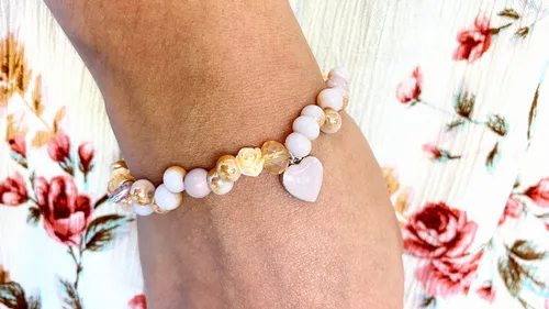 Armband auf Hand, zierlich geschmückt mit Rosen und Herz.