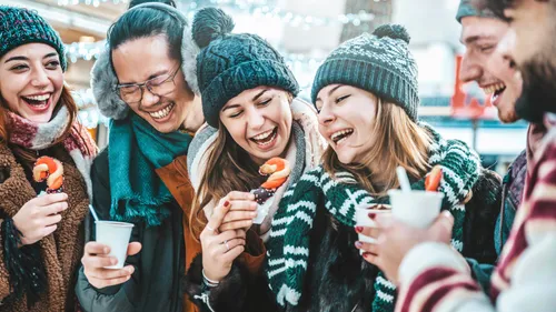 Gruppe von Freunden genießt winterliche Snacks und Getränke.