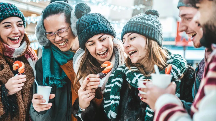 Gruppe von Freunden genießt winterliche Snacks und Getränke.