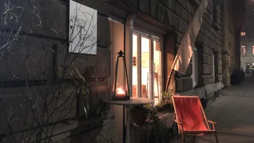 Hölzerner Stuhl steht draußen, eingehüllt in sanftes Licht.