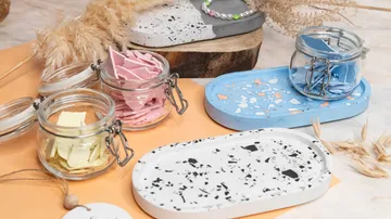 Bunte Schalen und Gläser mit bunten Stücken auf Tisch.