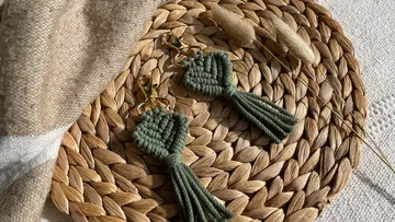 Green pendants lie on a woven trivet.
