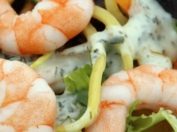 Prawns lie on a colorful salad dish.