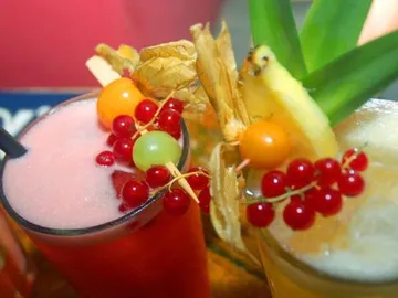 Colorful cocktails with fruits presented on a table.