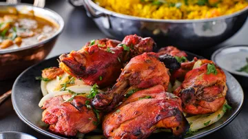 Grilled chicken on onions served with side dishes.