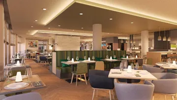 Moderne Restaurant mit Tischen, Stühlen und gedämpfter Beleuchtung.
