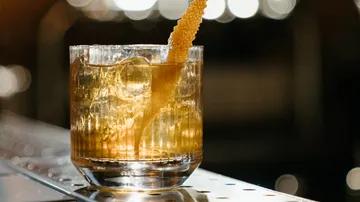 Ein Glas mit Eis und Honig auf einer Bartheke.