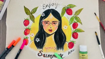 Porträt einer Frau mit Sonnenbrille, umgeben von Erdbeeren und Blumen.