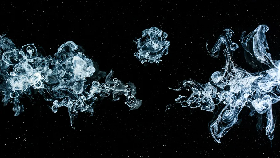 Clouds of smoke float in black space.