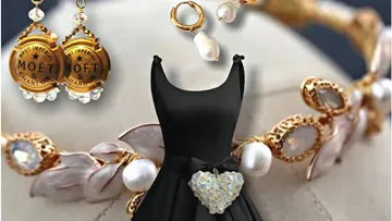 Black dress with jewelry and earrings on a table.