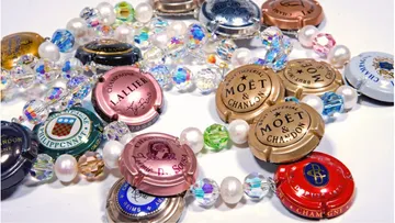 Colourful champagne caps form a decorative necklace made of pearls.