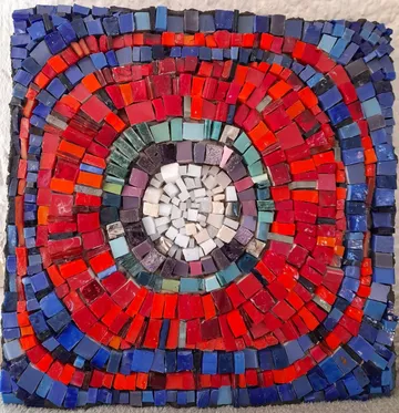 Bunte Mosaikplatte mit kreisförmigem Muster im Mittelpunkt.