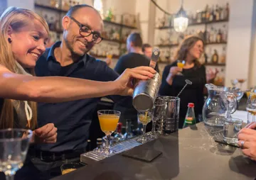 Bartender schüttet einen Cocktail in ein Glas an der Bar.
