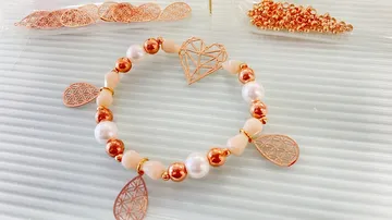 Armband mit Perlen und Anhängern auf einem Tisch.