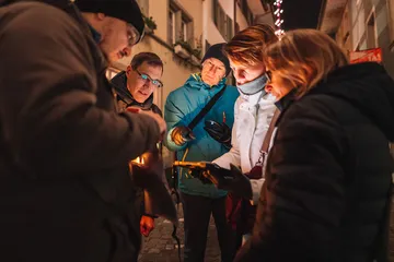 Leute, die eine Karte auf einer Nachtstraße studieren.