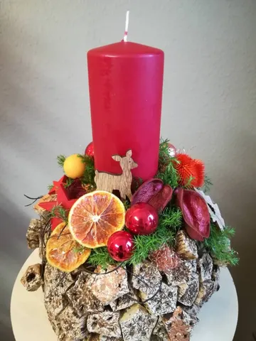 Red candle on decorative arrangement with dried fruit