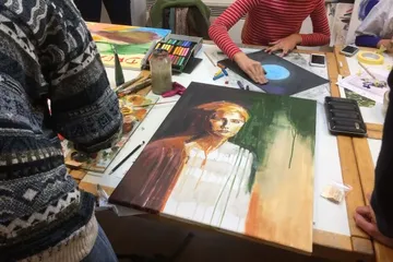Painting on a table, people working on works of art.