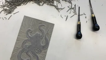 Eine gravierte Platte mit einem Oktopus und Werkzeugen.