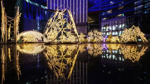 The glow of light is reflected in a water surface at night.