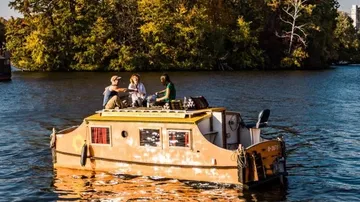 A boat swims with people in calm water.