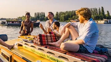 Four people relax on a boat on the water.