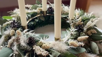 A wreath with candles decorates a table in a cozy room.