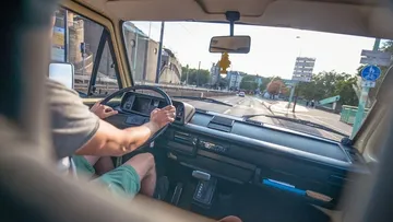 Fahrer steuert ein Auto auf einer Stadtstraße.