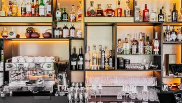 A bar with spirits and glasses, well-lit.