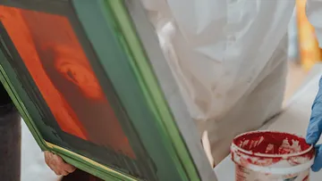The frame with an orange image is held in the hand.