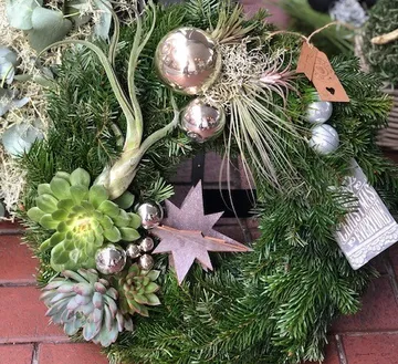Green wreath with plants and shiny Christmas decorations