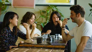 Four people try different products together in a café.