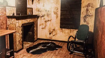 A rocking chair stands in a rustic carpeted room.