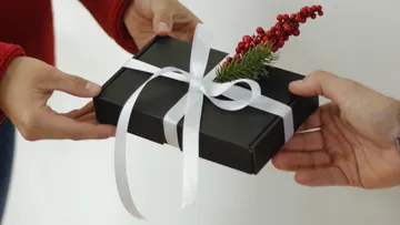 Geschenk wird von einer Person an eine andere übergeben.