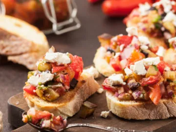 Toasted bread with fresh vegetables on a table.