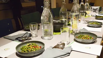 A set table with salads and bottles of water.