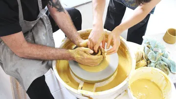 Potters make a mold out of clay together.