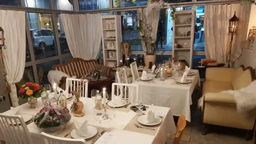 Gemütliches Restaurant mit gedeckten Tischen und dekorativer Umgebung.