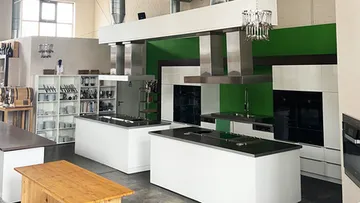 Moderne Küchenzeilen stehen in einem großen, hellen Raum.