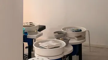 Schüsseln mit Handtüchern und Utensilien stehen auf Tischen.