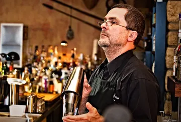 Barkeeper schüttelt einen Cocktail hinter der Bar.