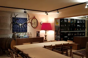 Rustic room with wooden table, lamp, drinks and decor.