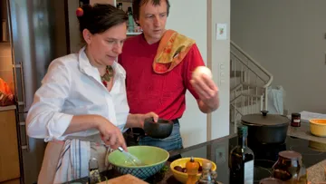 Zwei Personen kochen in einer modernen Küche zusammen.