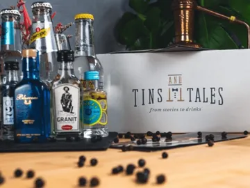 Flaschen mit Getränken stehen auf einem Tisch, umgeben von Deko.
