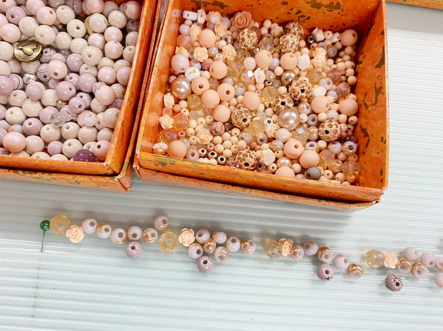 Pearls in boxes, sorted and arranged on a surface.