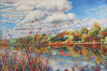 Colourful landscape reflected in water under cloudy sky.