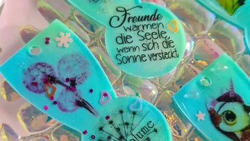 Colourful pendants with text and illustrations on a transparent background.