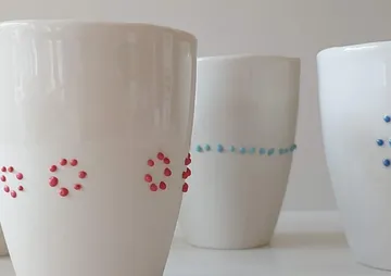 Mit einer Pipette gesetzte Porzellan-Pünktchen in verschiedenen Farben.