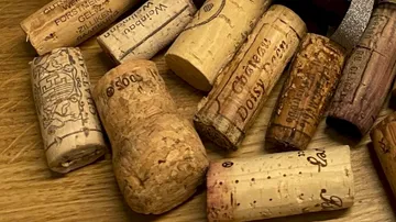 Wine corks are scattered on a wooden surface.