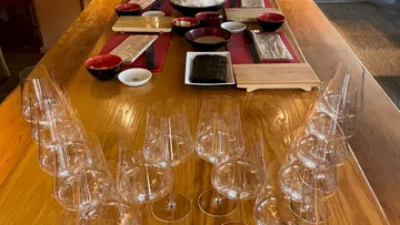 Glasses are placed on a table while food is being prepared.