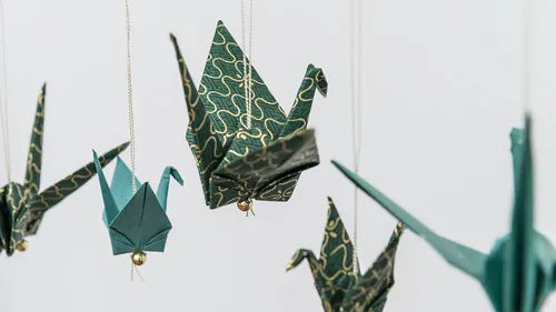 Paper cranes hang at lofty heights and float.